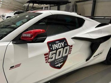 White sports car with Indy 500 decal on door.