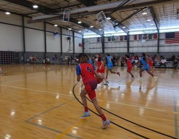 Youth basketball game in progress in an indoor gym.
