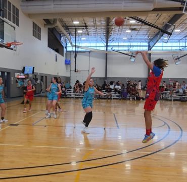 Youth basketball game with a player shooting a jump shot.