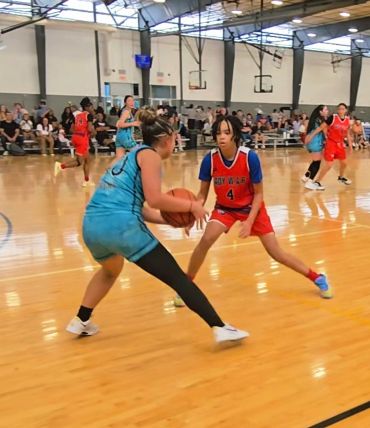 Youth basketball game with players in action on the court.