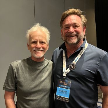 Two smiling men posing together at an event.