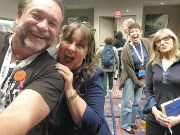 Four people smiling and posing happily indoors.