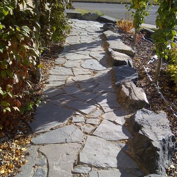 Natural Rundlestone walkway with accent boulders - leads to 2 sections of rock stairs and front entrance walk up bubbler and front porch cover pergola 