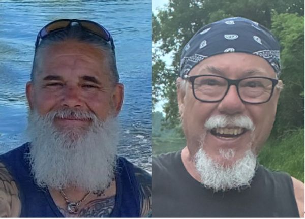 Two older men with white beards smiling outdoors.