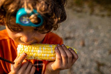 documentary photographer- boy eats corn