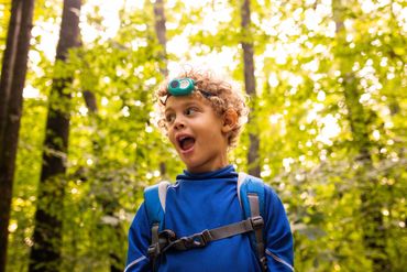 documentary photography- broad daylight toddler has a headlamp on his head