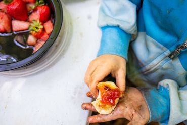 dirty hands hold a biscuit with jam. vacation photographer