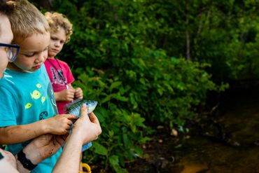 toddler touching fish documentary photogrpahy