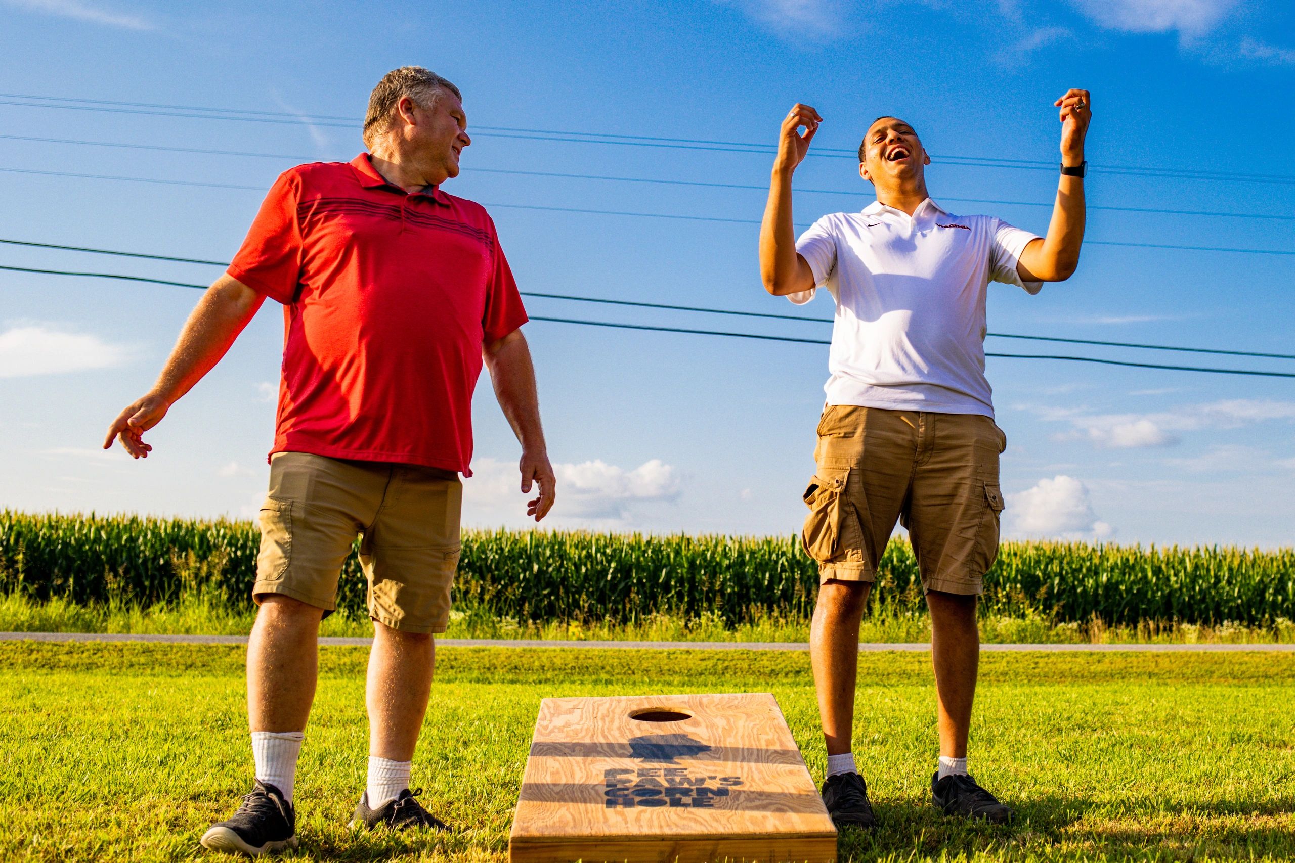 event photography-two men reacting to a corn hole game