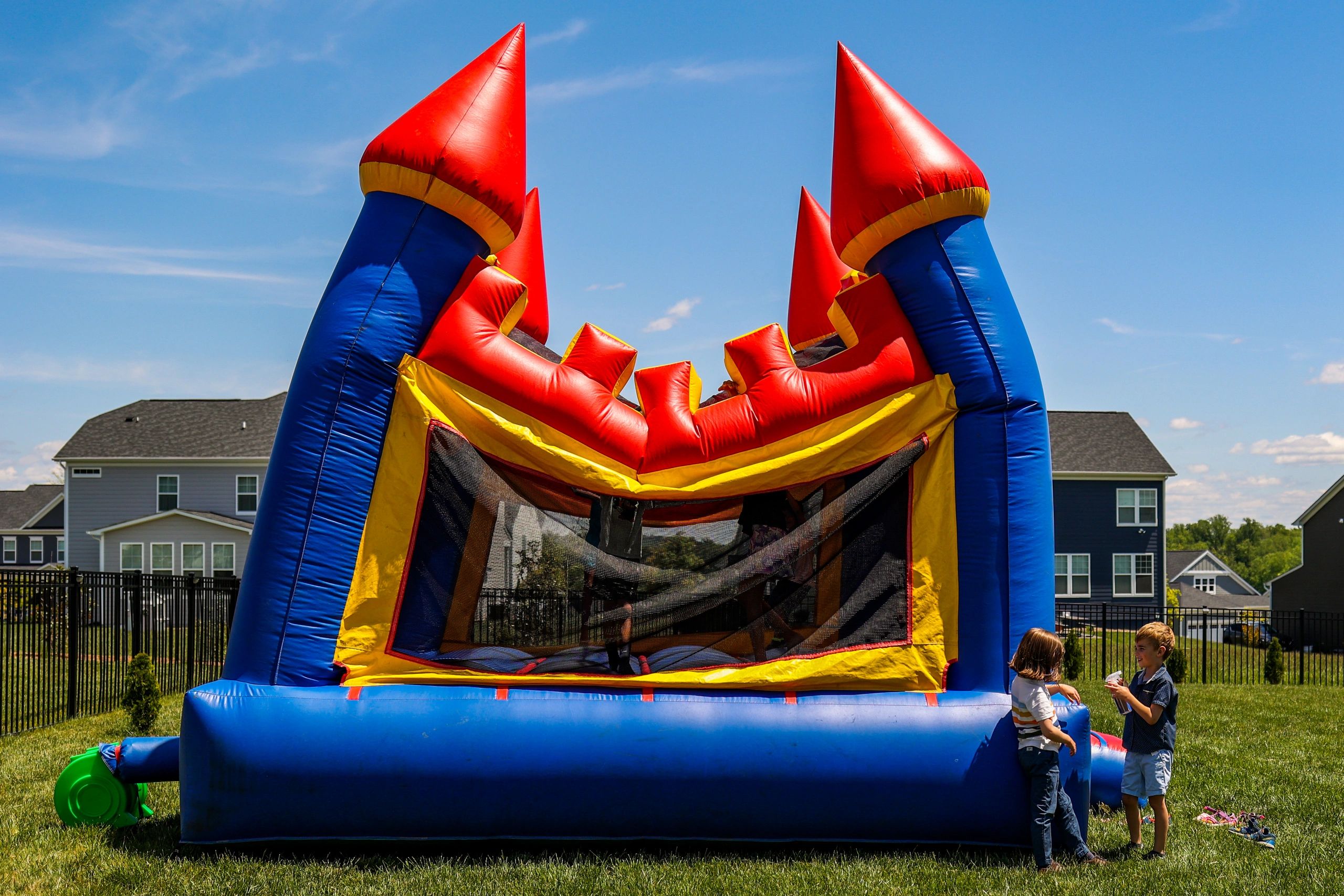 event photographer-two boys not noticing a jump castle falling next to them