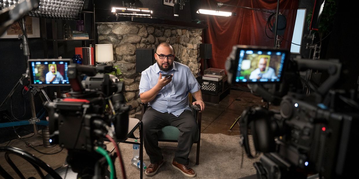 Man recording a video inside a studio with professional cameras and lighting.