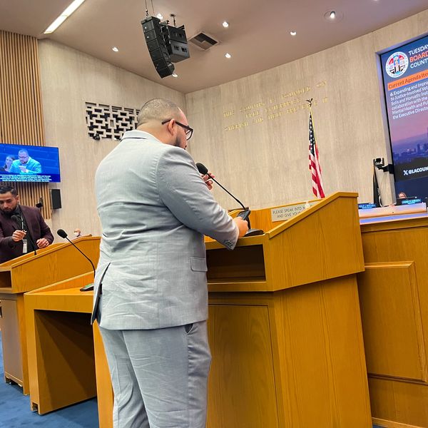 Man speaking at a podium during a Los Angeles Board of Supervisors meeting.