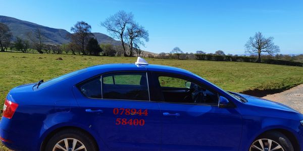 Blue taxi car parked on a rural road with phone number on the door.
call 07894458400
email talgarthtaxis@yahoo.com