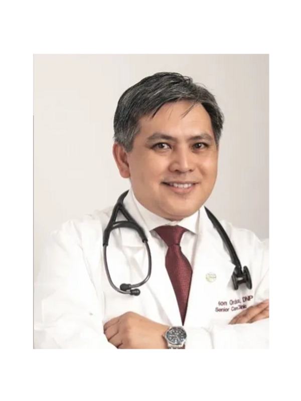 Smiling male doctor with stethoscope and red tie in white coat.