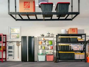 A garage with overhead racks, shelving, and cabinets