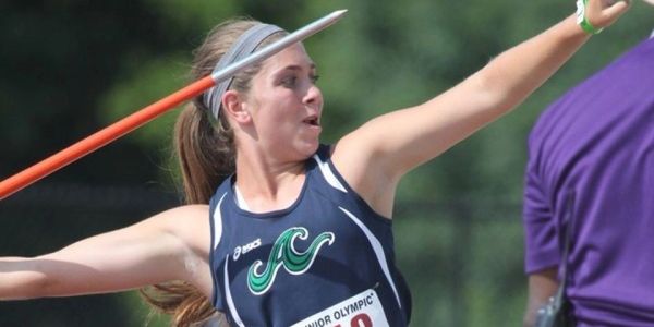 Female athlete preparing to throw a javelin in competition.