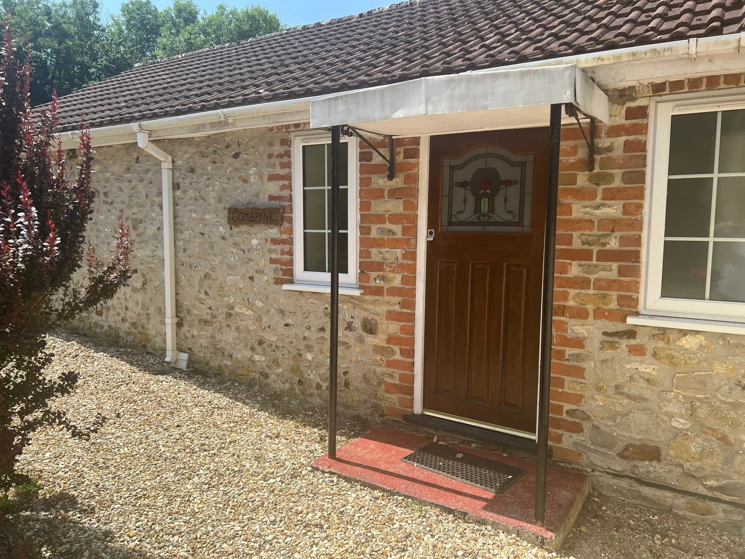 Entrance of a rustic stone cottage named Combyne.