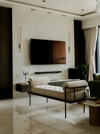 Modern living room with minimalist furniture and mounted TV.