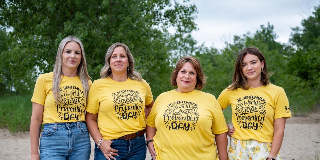 Group of women wearing yellow World Suicide Prevention Day shirts.