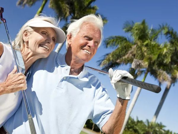 Older couple enjoying a sunny day playing golf.