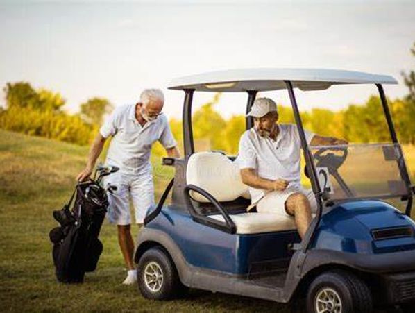 Two men with a golf cart and golf bags on a golf course.