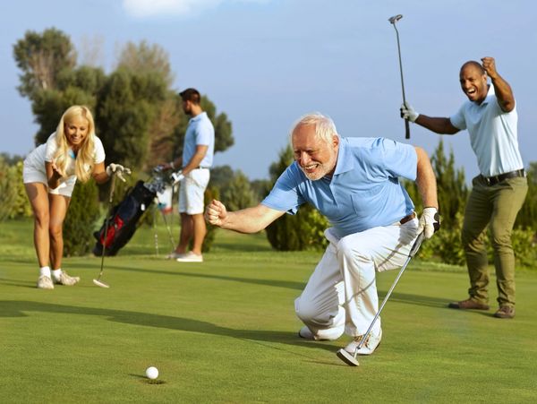 Seniors and younger adults celebrating golf success on the green.