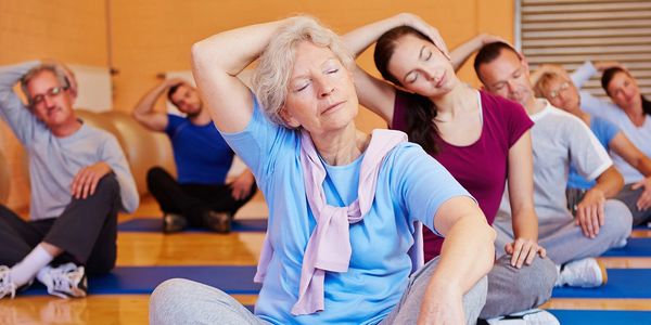 Group of seniors doing neck stretches in a fitness class.