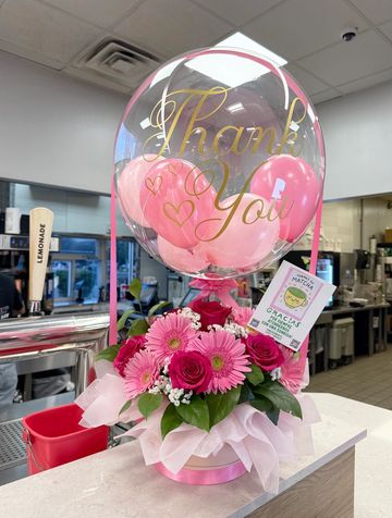 Thank You balloon with pink flowers on a counter.