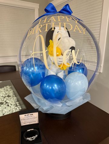 Birthday balloon with Snoopy plush and blue balloons for Alex.