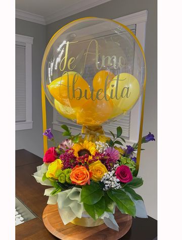 Colorful flower arrangement with a balloon saying 'Te Amo Abuelita'.