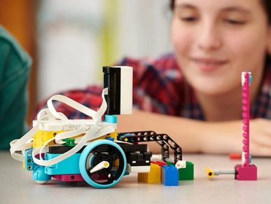 child looking at lego robotics creation in awe