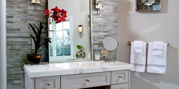 White Calcutta marble vanity with glass tile wall design