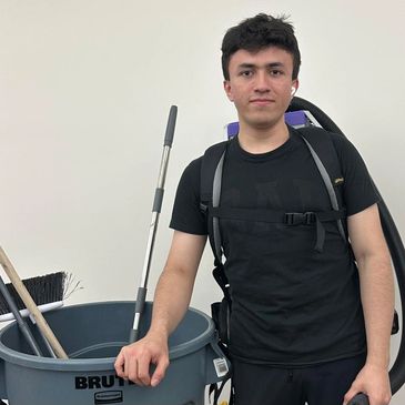 A young Branson team member using a professional backpack vacuum—showing efficiency.