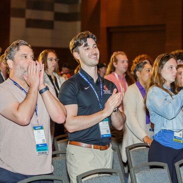 Crowd of people cheering and clapping.