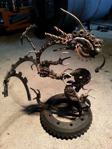 dragon made from metal scrap parts, chain, gears, drill bits, screws, bolts, springs