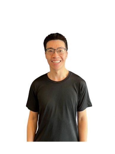 A smiling man wearing glasses and a black t-shirt against a white background.