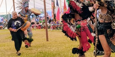 Dancers in traditional Aztec costumes performing at a cultural event.