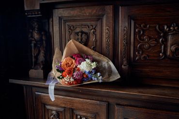 A bouquet of flowers on a wooden cabinet.