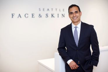 A man in a suit smiling at Seattle Face &amp; Skin clinic.