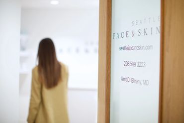 Woman walking past a clinic sign.