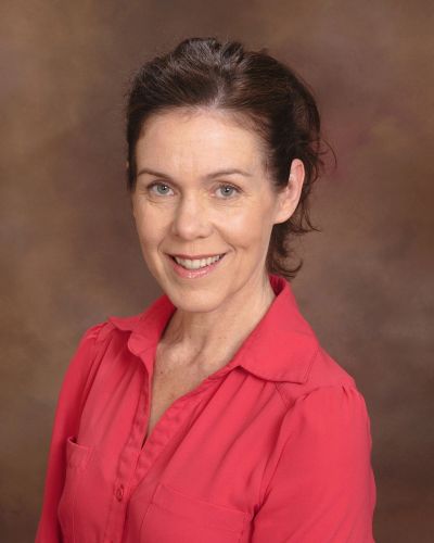 Woman in red shirt smiling at camera.