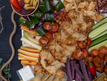 Indian platter with assorted dishes and condiments, purple carrots, naan, tikka chicken, chilli
