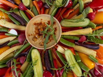 Crudité platter with vibrant fresh vegetables and creamy hummus dip