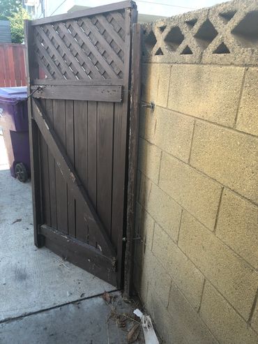 Alley gate is completely detached from the wall.