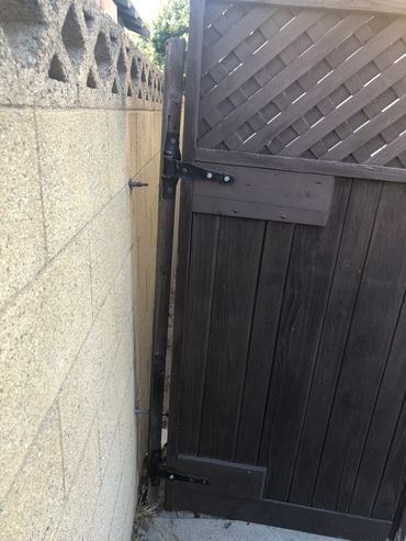 Back gate is detached from the wall.  It's just leaning against the wall & garage.