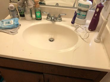 Bathroom sink countertop is cracked.