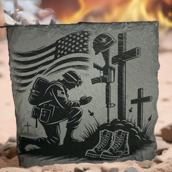 Engraved soldier kneeling in respect at a battlefield memorial with crosses and boots.