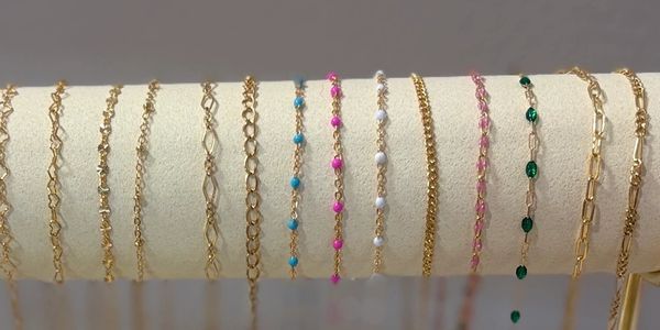 Gold and colored chain bracelets on display.