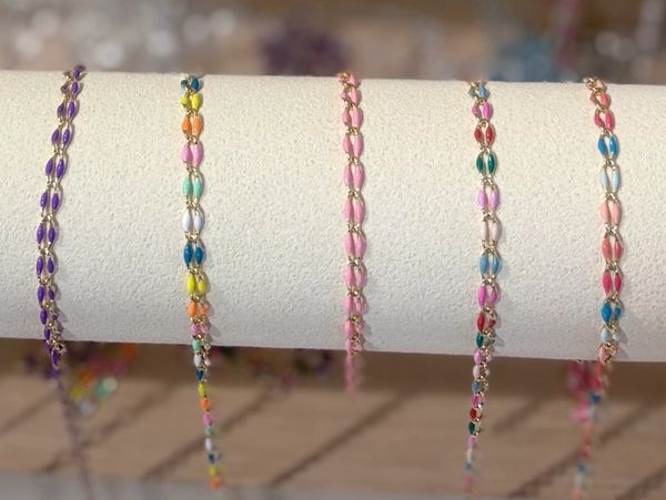 Gold and colored chain bracelets on display.