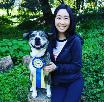 Karena Leong and Lexi Celebrating after obtaining an AKC Novice Trick Dog Title Ribbon